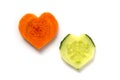 Carrot and cucumber. 2 slices in heart shape isolated on white background. Couple relationship concept. Difference versus similari