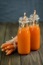 Carrot juice and baby carrots on a dark wooden background Royalty Free Stock Photo