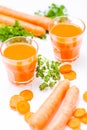 Carrot juice in beautiful glasses, cut orange vegetables and green parsley on white wooden background. Fresh orange drink. Close u Royalty Free Stock Photo