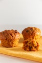 Carrot muffins on a white background. Homemade cakes on a yellow napkin. Vertical photo