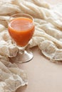 Carrot orange juice in a vintage glass on vintage gauzy textile
