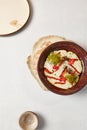 Carrot soup with creamy espuma in dark ceramic bowl. Vegetable cream soup in modern dishware with hard shadow