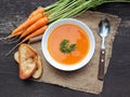 Carrot soup with fresh herbs and bread on wooden table Royalty Free Stock Photo