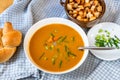 Carrot soup in plate, bread, onion shoot and piece of fried bread in bowl Royalty Free Stock Photo