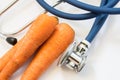 Carrot and stethoscope. Stethoscope tests three carrots for presence of GMO, diseases, varieties. Nutrition and health benefits of Royalty Free Stock Photo