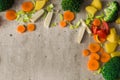 Carrots, broccoli, parsley root, leek, tomato and potatoes on a gray stone