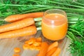 Carrots and carrot juice on wooden background. Healthy food. Royalty Free Stock Photo