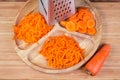 Carrots grated in different ways with kitchen grater, whole uncleaned carrot Royalty Free Stock Photo