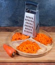 Carrots grated in different ways, whole carrot and kitchen grater Royalty Free Stock Photo