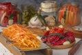 Carrots grated on a hand grater on the background of differentiated products - pepper, garlic, carrots on a wooden table