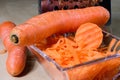 Carrots take off on a kitchen grater. Kitchen countertop and preparation of salads.