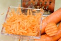 Carrots take off on a kitchen grater. Kitchen countertop and preparation of salads.