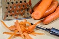 Carrots take off on a kitchen grater. Kitchen countertop and preparation of salads.