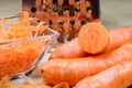 Carrots take off on a kitchen grater. Kitchen countertop and preparation of salads.