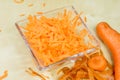 Carrots take off on a kitchen grater. Kitchen countertop and preparation of salads.