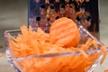 Carrots take off on a kitchen grater. Kitchen countertop and preparation of salads.