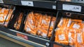 Carrots wrapped in cellophane for sale in a supermarket.