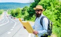 Carry good map. Tourist backpacker looks at map choosing travel destination at road. Around the world. Find map large