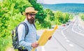 Carry good map. Tourist backpacker looks at map choosing travel destination at road. Around the world. Find map large