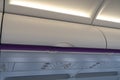 Carry-on luggage in overhead storage compartment on commercial airplane Royalty Free Stock Photo