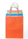Carrying goods concept. Multicolored empty reusable paper shopping bags with handles isolated on white background