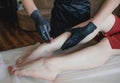 Carrying out the depilation procedure . A confident professional depilation master is preparing to apply wax to the