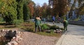 Carrying out landscaping of the park by Zelenstroy workers. People walking in the park alley