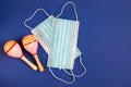 Carrying out a traditional national carnival during the Yema pandemic. Medical Protective Masei Maracas Blue Background Copy space