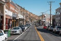 Cars on asphalt road amidst old shops at vintage city during sunny day