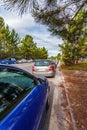 Cars or automobiles parked over the curb into sidewalk, leaving no space for pedestrians in the walkway. Road accessing a suburban