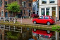 Cars on canal embankment in street of Delft. Delft, Netherlands Royalty Free Stock Photo