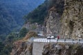 cars carrying tourists on the narrow dangerous mountain road in beautiful Himalayas mountains with steep slopes in Bhutan