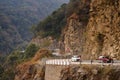 cars carrying tourists on the narrow dangerous mountain road in beautiful Himalayas mountains with steep slopes in Bhutan