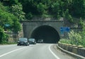 Cars come out of the road tunnel. Road traffic on a street that crosses the mountains. Royalty Free Stock Photo