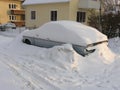 Cars covered in snow on a street in town in Karlskrona