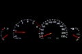 A cars dashboard panels lit up at night with European speedometer