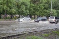 Cars drive through deep puddles on the road after rain