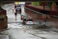 Cars drive through a flooded railway underpass after heavy rain