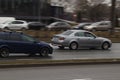 Cars drive on the street in the rain. Motion blur. Riga, Latvia - 04 Apr 2022