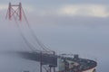 Cars driving across the bridge in the dense fog