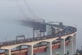 Cars driving across the bridge in the fog