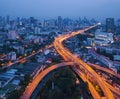 Cars driving on bridge roads shaped curve highways with skyscraper buildings. Aerial view of Expressway Bangna, Klong Toey in