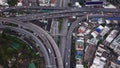 Cars driving on bridge roads shaped curve highways with skyscraper buildings. Aerial view of Expressway Bangna, Klong Toey in