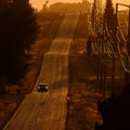 Cars Driving on County Road at Sunset or Sunrise Royalty Free Stock Photo