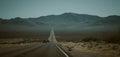 Cars driving down a deserted highway against mountains in the United States