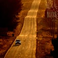 Cars Driving on County Road at Sunset or Sunrise Royalty Free Stock Photo