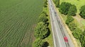 Cars driving on the road between two big fields. Royalty Free Stock Photo