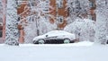 Cars driving on snowy road in winter in the city, snowfall, blizzard