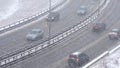 Cars driving on snowy road in winter, traffic on highway in snowfall, blizzard