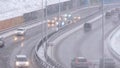 Cars driving on snowy road in winter, traffic on highway in snowfall, blizzard